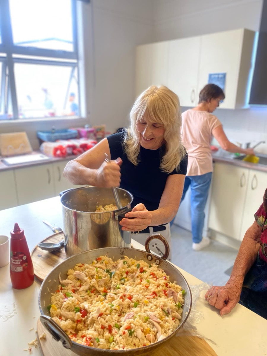 Encounter Bream Bay women serving food together in the church kitchen